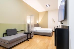 米兰Castello Guest House Milano的客房设有床、沙发和桌子。