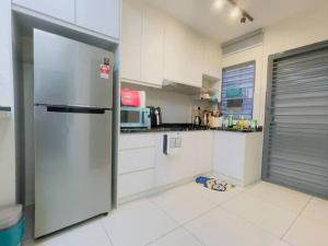 瓜拉雪兰戈Double Storey Sweet Home 12pax @ Puncak Alam的厨房配有不锈钢冰箱和白色橱柜