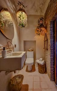 舍夫沙万Casa Amina的一间带水槽、卫生间和吊灯的浴室
