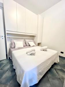 斯波托尔诺A 5 minuti dal mare - Dolphin Beach House的白色卧室配有两张带毛巾的床