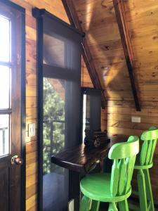 托塔Playa Blanca - Glamping Bethél的小木屋内两张绿色椅子,坐在木桌旁