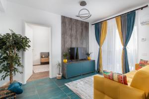 奥拉迪亚Talida's apartment colorful and brightnes的客厅设有黄色沙发和电视