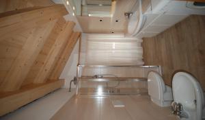 博萨迪法萨西亚萨拉瑟姆公寓的一间带卫生间的浴室和一个带木墙的楼梯