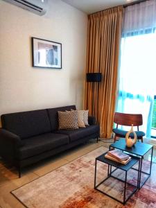 普特拉贾亚Staycationbyrieymona - 3BR Condo, CLIO 2, Putrajaya的客厅配有黑色沙发和桌子