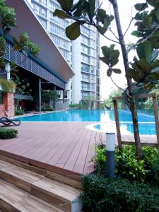 普特拉贾亚Staycationbyrieymona - 3BR Condo, CLIO 2, Putrajaya的大楼内游泳池旁的木人行道