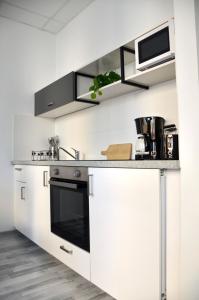维也纳Apartman Favorita的厨房配有白色橱柜和黑烤箱。