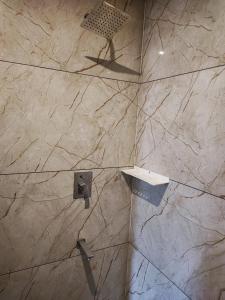 马迪凯里Kamadhenu Residency Homestay Hotel Coorg Madikeri的浴室设有石墙和淋浴。