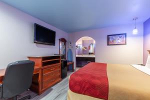 休斯顿Summit Inn - Houston Medical Center - NRG Park的酒店客房配有一张床、一张书桌和一台电视。