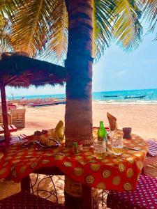 NianingMaison Couleur Passion的海滩上棕榈树下的桌子
