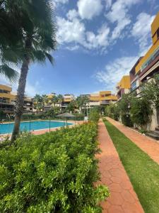 弗拉门卡海滩Casa Palmera - El Bosque - Playa Flamenca的一个带游泳池和棕榈树的度假村