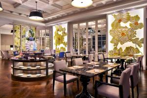 郑州河南中州皇冠假日酒店的一间带桌椅和鲜花墙的餐厅