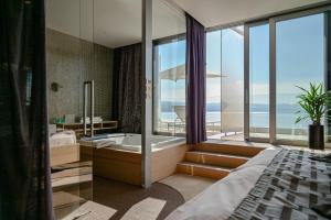 奥帕提亚Bevanda Hotel & Restaurant - Unique Adriatic的一间带浴缸、一张床和窗户的卧室