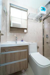 胡鲁马累White Beach Holiday的一间带卫生间、水槽和镜子的浴室