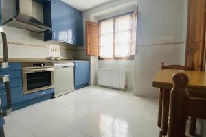 利亚内斯apartamentos lleguera 1的厨房配有蓝色橱柜和桌子