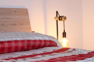 卡瓦莱塞IL CERVO - Dolomiti Affitti的一间卧室配有一张带红色枕头和灯的床