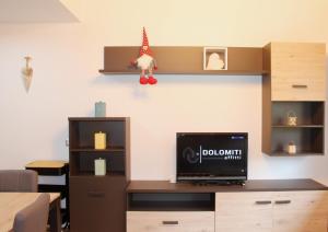 卡瓦莱塞IL CERVO - Dolomiti Affitti的客房设有一张桌子,墙上配有电视