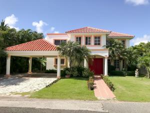 ParaísoVilla impecable con piscina privada en Juan Dolio的一座红色屋顶和棕榈树的房子