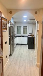 萨拉曼卡Cembe的一间铺有木地板的大厨房,配有白色的橱柜