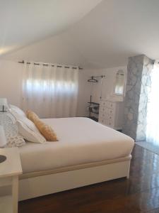 坎德拉里亚Sunset Las Hadas的卧室配有白色大床和梳妆台