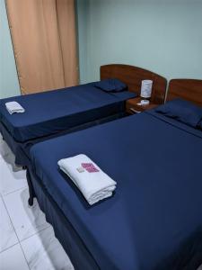 莱昂Cuartos Casa Blanca的两张带蓝色床单和白色毛巾的床