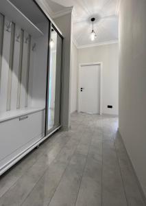 基希讷乌OASIS, Charming 1BD apartment with living room的一条空的走廊,有大窗户和门