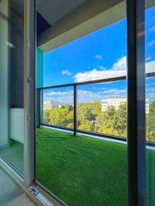 基希讷乌OASIS, Charming 1BD apartment with living room的客房设有带绿草的大窗户。