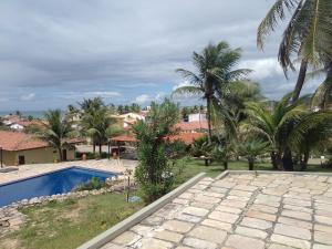 尼西亚弗洛雷斯塔Condomínio Mar de Búzios的一个带游泳池和棕榈树的度假村