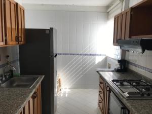 圣玛尔塔Apartamento Los Laureles Rodadero的厨房配有黑色冰箱和水槽