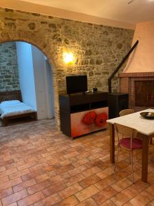布鲁法Casale in collina vista Assisi,Brufa di Torgiano的客厅设有石墙和桌子