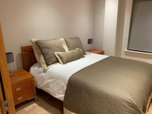 基拉尼Killarney Town Apartment的一间卧室设有床、两个床头柜和窗户