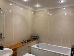 基拉尼Killarney Town Apartment的带浴缸、卫生间和盥洗盆的浴室