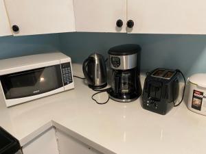 萨里jane's cozy suite的厨房柜台配有微波炉和咖啡壶