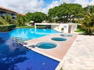 塔曼达雷Carneiros Beach Resort - Apto 214D的周围设有蓝色瓷砖的大型游泳池