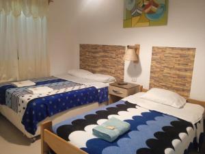帕拉卡斯Hostal Brisa Marina的一间卧室设有两张床和窗户。