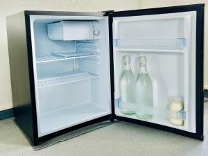 北帕默斯顿Charm on Chippendale B&B的配有2瓶牛奶的开放式冰箱