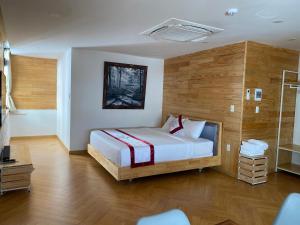 大叻Feliz Dalat Homestay的一间卧室配有一张木墙床