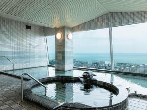 淡路KAMENOI HOTEL Awajishima的享有城市景致的建筑内的热水浴池