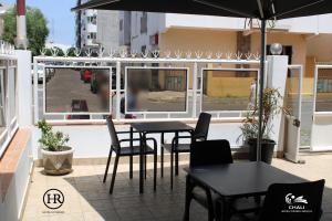 普拉亚Hotel Roterdão "Under New Management"的庭院配有桌椅和窗户。
