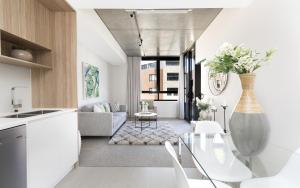 金斯顿Azure 30的厨房以及带白色家具和花瓶的客厅。