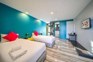 普吉镇Nam Naka Boutique Hotel - SHA Plus的一间卧室设有两张床和蓝色的墙壁