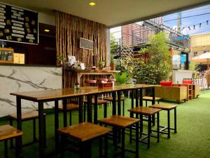 普吉镇Nam Naka Boutique Hotel - SHA Plus的一间在房间内配有桌椅的餐厅