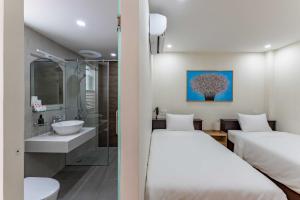 胡志明市Edoya hotel Dong Khoi的配有2张床的酒店客房 - 带浴室