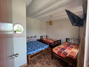 帕查卡马克Casa de Campo Pachacamac (Hasta 21 personas)的一间卧室配有两张床和一台平面电视