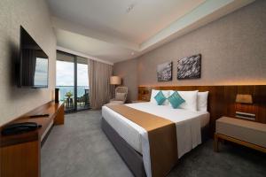 麦克坦The Reef Island Resort Mactan, Cebu的酒店客房设有一张大床和一台电视。
