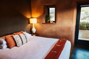 约书亚树Sacred Sands的一间卧室配有带枕头和台灯的床
