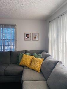 拉斯维加斯Downtown home with Jacuzzi的客厅配有带黄色枕头的灰色沙发