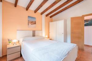 普伊彭耶特Finca Ses Pomeres的卧室设有白色的床和木制天花板。