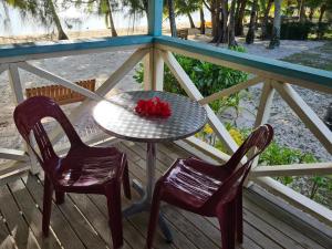 AmuriSunny Beach Bungalows - Aitutaki的门廊上的一张桌子和两把椅子