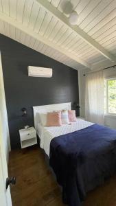 TamaniqueTreehouse的一间卧室配有一张带蓝色床单和粉红色枕头的床。