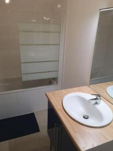 弗雷埃勒Mer et calme的浴室设有白色水槽和镜子